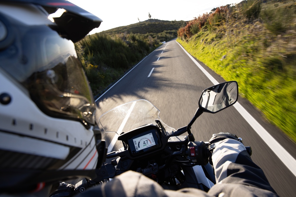 Motorcyclist riding on an open road during spring, highlighting safe riding conditions after winter in New Jersey