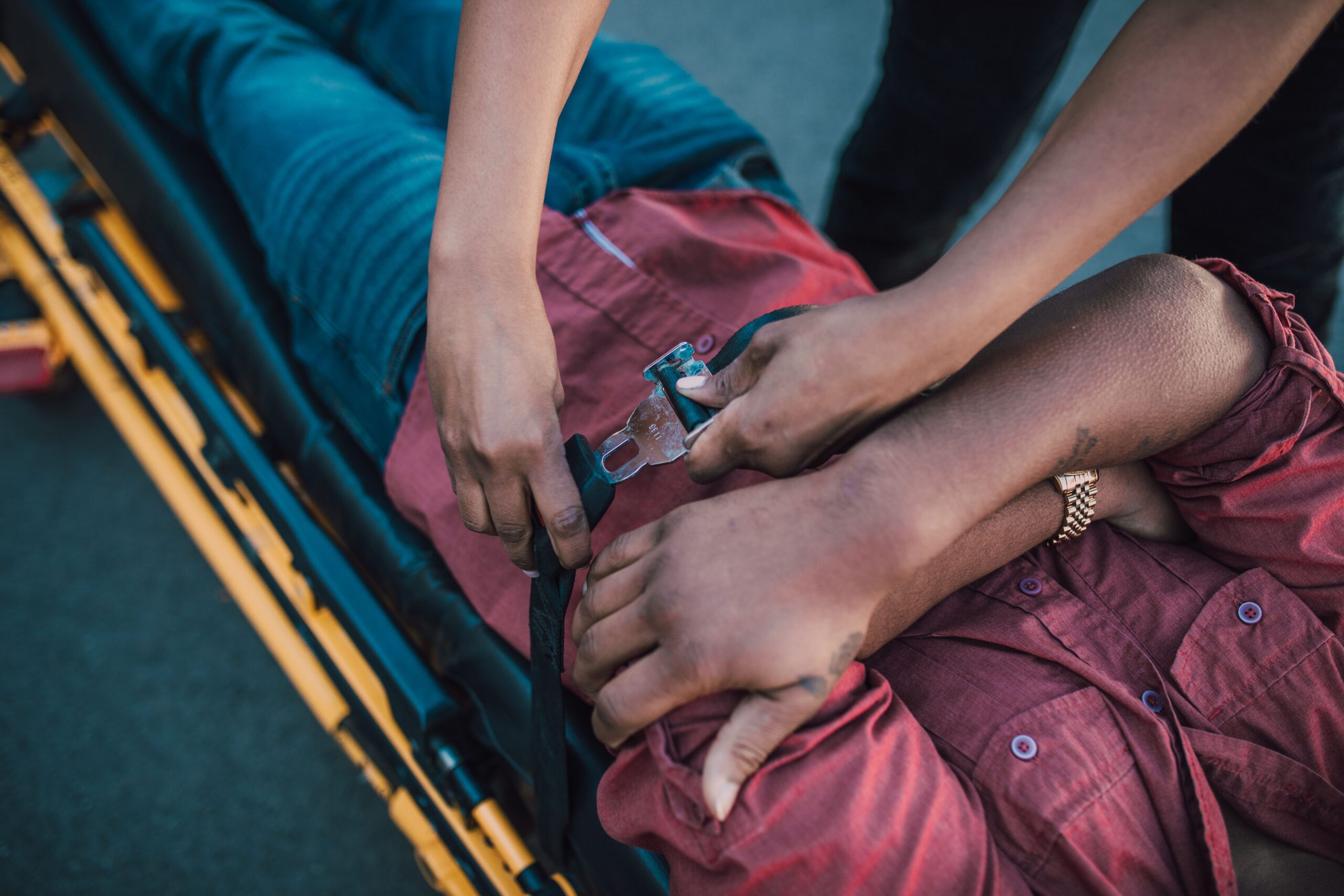 Paramedics strapping an injured motorcycle accident victim onto an ambulance stretcher after a crash